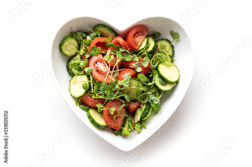 Fresh salad with tomato, cucumber, vegetables, microgreen radishes. Top view. Concept vegan and healthy eating.