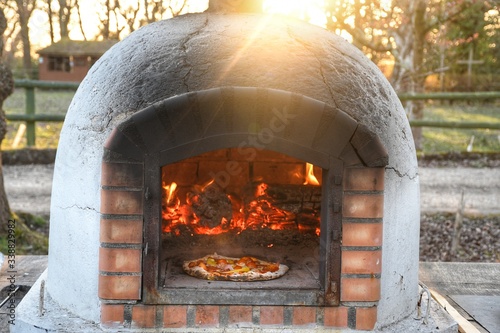 hand made pizza cookin in pizza oven with Wood fire
