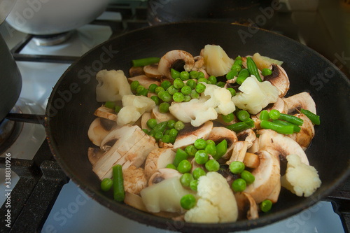 Champignons cauliflower peas peas and green beans stewed in black skillet