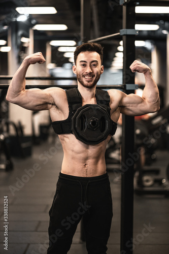 Man during workout in the gym  Concept  power  strength  healthy lifestyle  sport. Powerful attractive muscular Man CrossFit trainer do battle workout with ropes at the gym. Young man exercising using