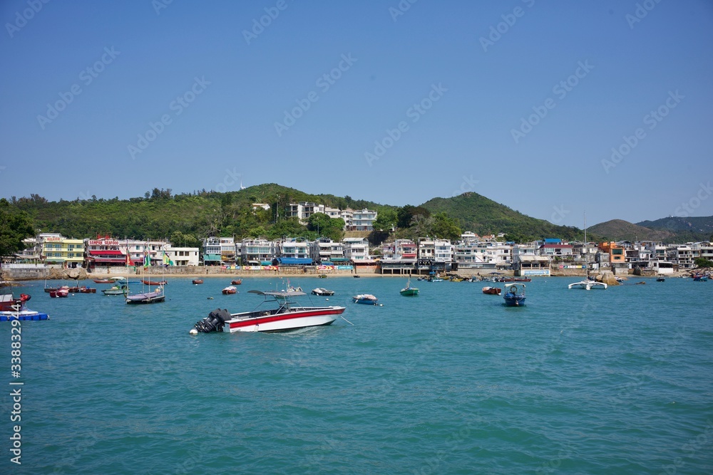 Obraz premium Lamma Island, Hong Kong - 12 April 2020 : Weekend travel capture, landscape of the coast next to Yung Shue Wan ferry pier at the island north, boat flowing next by.