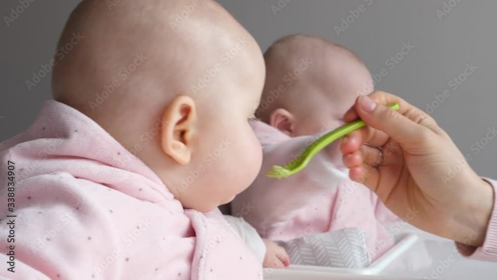 Feeding Cute Baby Girls With Spoon. Twins Feeding. Feeding Cute Baby Girls With Spoon. Twins Feeding.