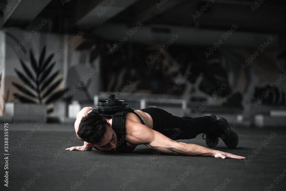 Fototapeta premium Man during workout in the gym Concept: power, strength, healthy lifestyle, sport. Powerful attractive muscular Man CrossFit trainer do battle workout with ropes at the gym. Young man exercising using