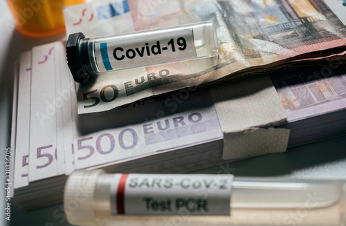Coronavirus vial on euro banknotes, conceptual image