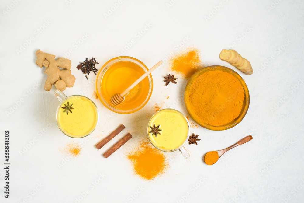 Indian traditional Golden milk with turmeric, ginger, spices, honey. healing effect of the drink. ingredients for a Golden drink on a light background. antiviral antioxidant. the view from the top