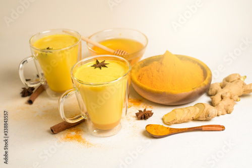 Indian traditional Golden milk with turmeric, ginger, spices, honey. healing effect of the drink. ingredients for a Golden drink on a light background. antiviral antioxidant. the view from the top