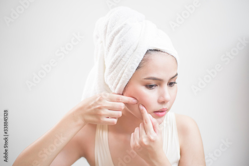 A woman is popping a pimple
