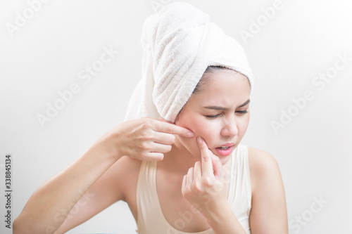 A woman is popping a pimple