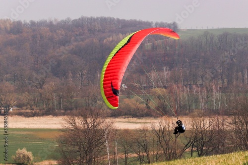 A paraglider´s flight over meadow in spring 