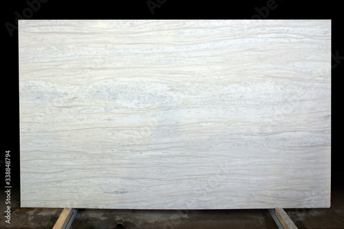 A large slab of white marble with stripes and dots called Nestos Beige