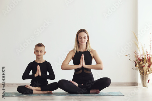 mother and son doing yoga on the quarantine at home (sports exercises), have fun and spend a good time together . isolated on white. the concept of a healthy lifestyle (COVID - 19)