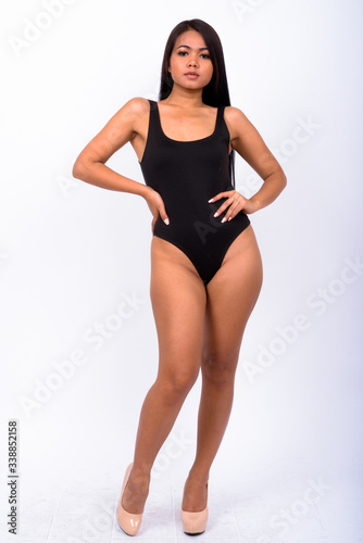 Young Asian woman wearing swimwear against white background