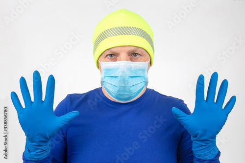 Portrait of a man in a medical mask with raised hands in protective gloves. clean hands and quarantine
