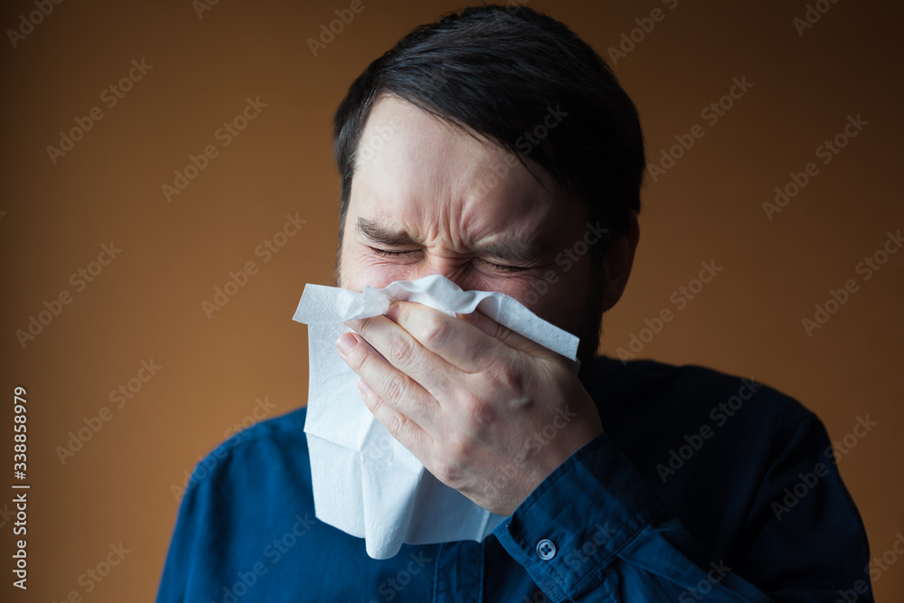 European man with dark hair violently sneezing in handkerchief European man with dark hair violently sneezing in handkerchief