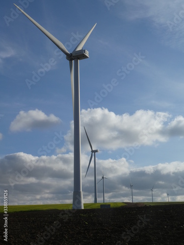 Row of six wind turbines in a field in France