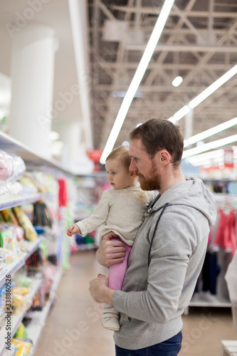young father with small baby shopping in supermarket.