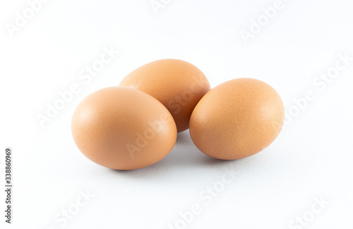 Close up of three organic raw brown chicken eggs isolated with white background