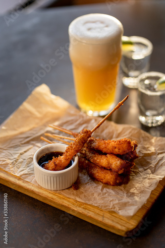 frying shrimps on wooden board with glass of beer