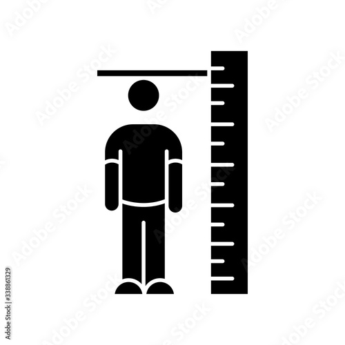 Height measurement black glyph icon. Human body size determination. Tailoring parameters, body growth silhouette symbol on white space. Person standing near huge ruler vector isolated illustration