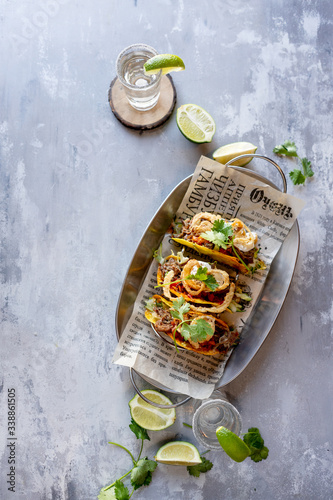 Mexican meat tacos with tequila shots on stone background