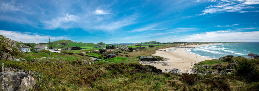 Panoramic view of a long Hellestostranden sand beach and surrounding area with green hills and fields near Stavanger city, Norway, May 2018