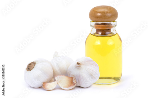 Garlic bulb and cloce with oil extract in glass bottle isolated on white background. Healthy food or herbal natural medicine plant concept. photo