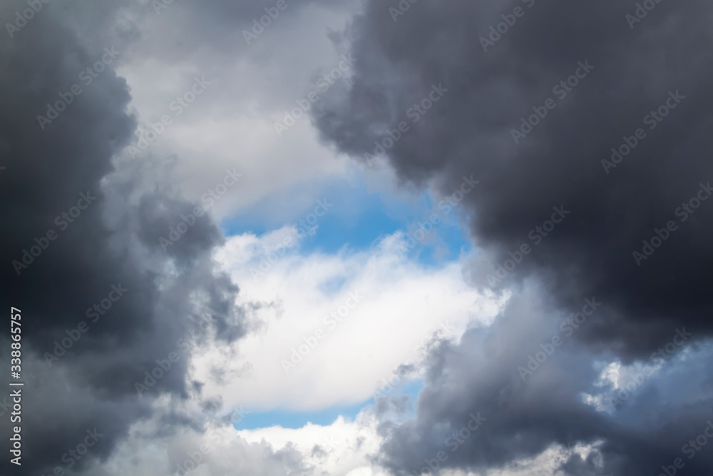 stormy grey and white clouds on blue sky background