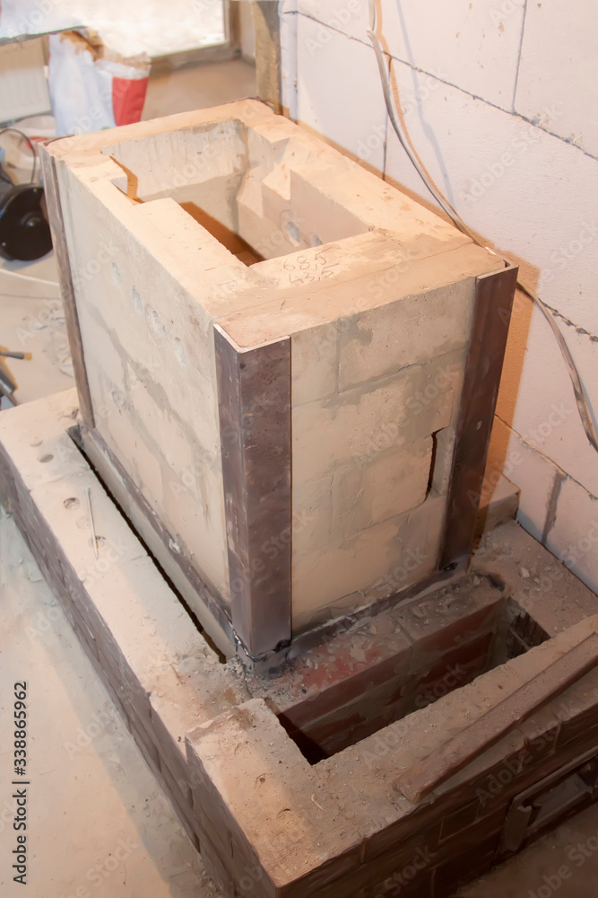 Sauna stove that is being built from fire resistant material in undeveloped interior laid out of foam blocks in country house under construction Sauna stove that is being built from fire resistant material in undeveloped interior laid out of foam blocks in country house under construction