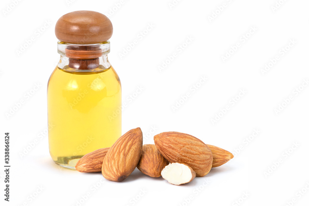 Closeup almond oil in glass bottle and group of almond nuts with slice isolated on white background. Closeup almond oil in glass bottle and group of almond nuts with slice isolated on white background.