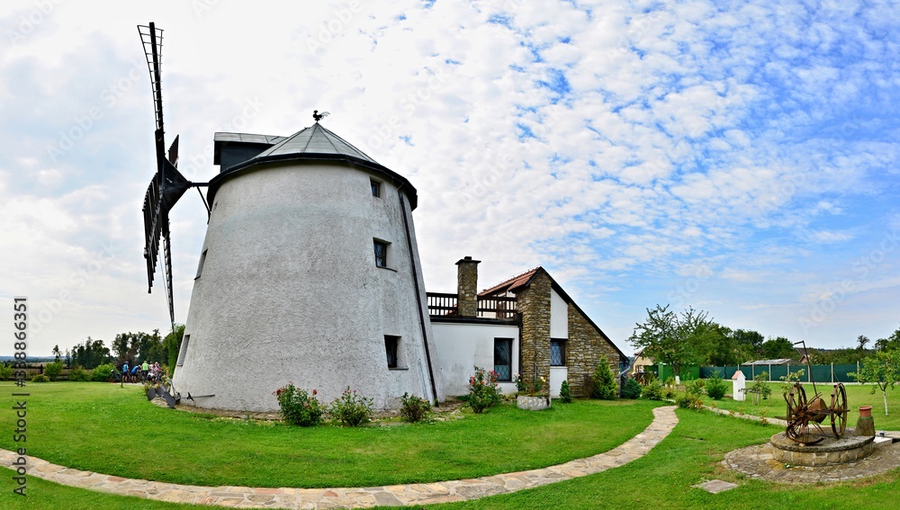 Windmill on green field with sky and clouds in background. Windmill on green field with sky and clouds in background.