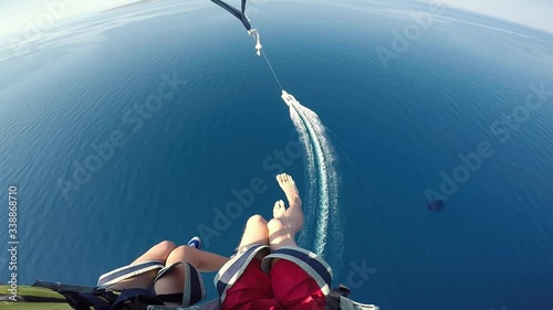 Young couple parasailing tied to speed boat over Adriatic sea Croatia action camera POV. Amazing Adriatic vacation holiday honeymoon in Croatia destination