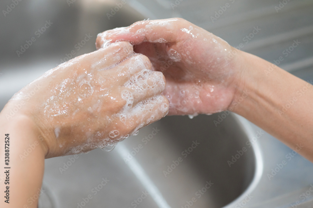 Close up woman hand washing under running water in the kitchen.Hygiene and cleaning Hands.Image hand washing step concept.