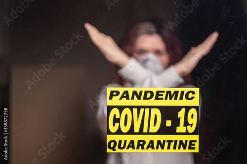 Woman in respiratory mask showing stop gesture. Girl show gesture no. Stop coronavirus or covid-19 and the pandemic. Stay home. Quarantine concept.