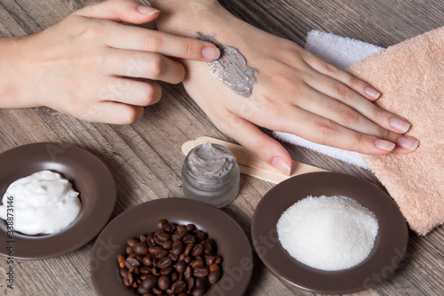 A woman applies a natural coffee scrub to the skin. Homemade scrub made of sugar  salt  cream and coffee. Beauty  Spa  skin care  aromatherapy. Moisturizing  peeling  exfoliation