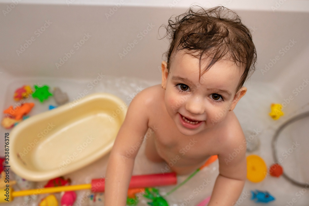 Little girl bathes in a bathtub with toys Little girl bathes in a bathtub with toys