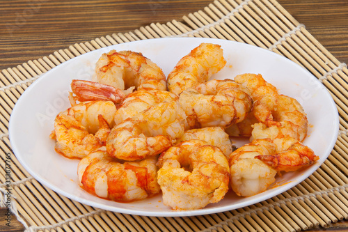 delicious appetizing prawns on white plate on wooden