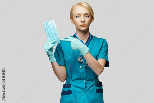 medical doctor nurse woman with stethoscope over light grey background - showing protective mask