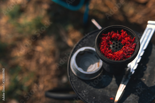 Fototapeta Naklejka Na Ścianę i Meble -  Silicone bowl with a gas station for smoking, tobacco, mix, concept smoking a hookah on nature, outdoor. selective focus. Close up, copy space for text