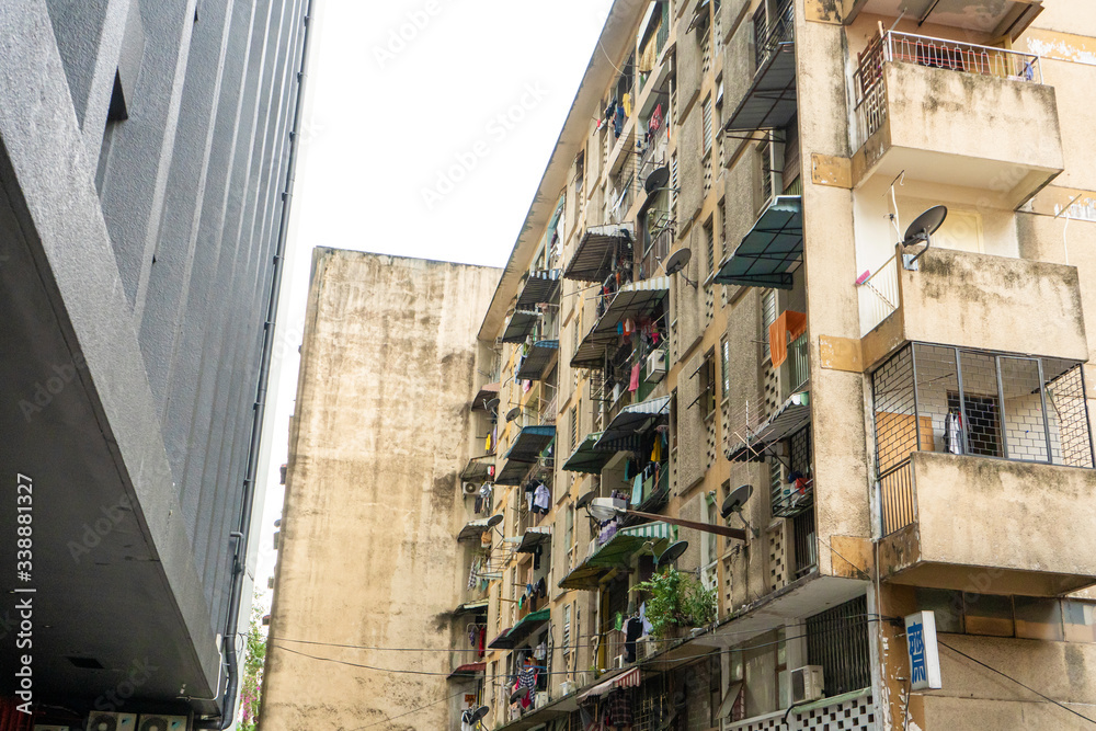 The balconies of an apartment building are hung with clothes. The poor area. Moments of Ordinary Life