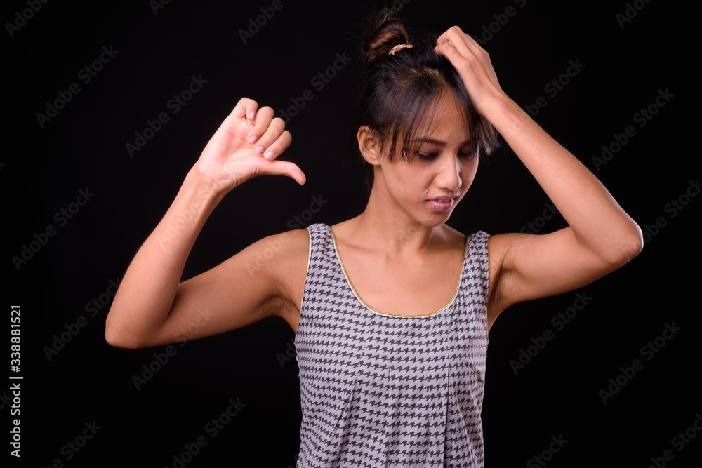 Young beautiful Asian woman against black background Young beautiful Asian woman against black background