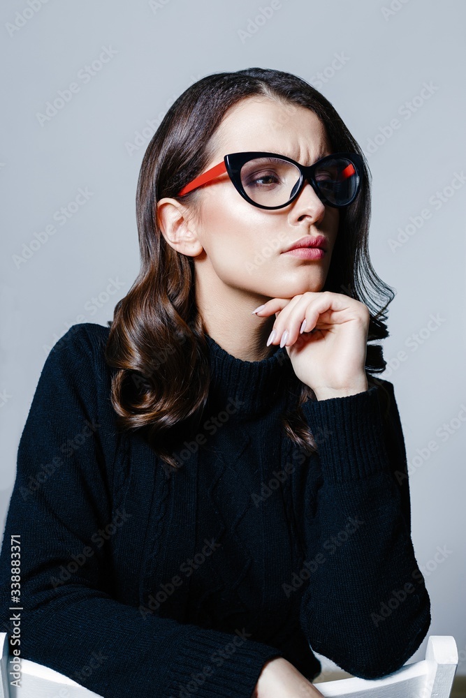 Portrait of young brunette woman with a healthy clean skin. Young beautiful business woman in stylish glasses and white shirt posing in studio. Portrait of young brunette woman with a healthy clean skin. Young beautiful business woman in stylish glasses and white shirt posing in studio.