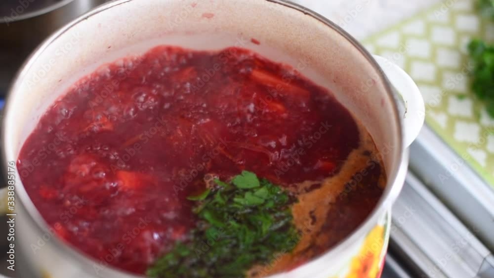 fresh red borscht is cooked on the stove with fresh herbs fresh red borscht is cooked on the stove with fresh herbs