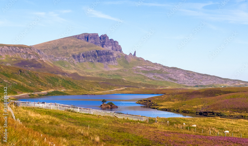 Isle of Skye, Scotland / UK: Tiny island in the middle of Loch Fada with the Old Man of Storr in the distance