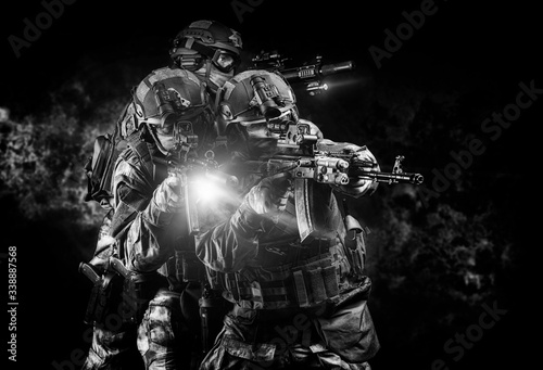 Billede på lærred American soldiers in combat ammunition with weapons in the hands of equipped laser sights are in battle order