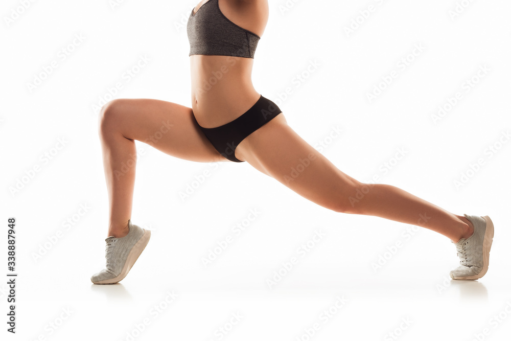 Beautiful female legs and belly on white background. Beauty, cosmetics, spa, depilation, treatment and fitness concept. Fit and sportive, sensual body with well-kept skin in underwear. Training. Beautiful female legs and belly on white background. Beauty, cosmetics, spa, depilation, treatment and fitness concept. Fit and sportive, sensual body with well-kept skin in underwear. Training.