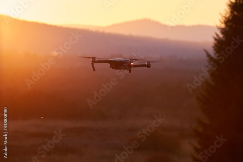 Drone flying at the sunset on red sky