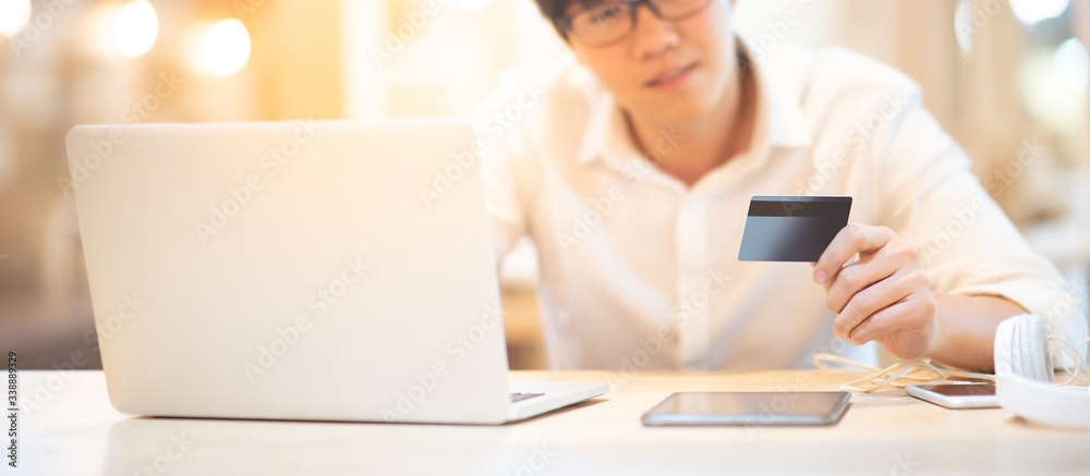Asian man customer using credit card for online shopping during quarantine at home. Male shopper buying goods and making payment with electronic banking. Financial technology concept Asian man customer using credit card for online shopping during quarantine at home. Male shopper buying goods and making payment with electronic banking. Financial technology concept