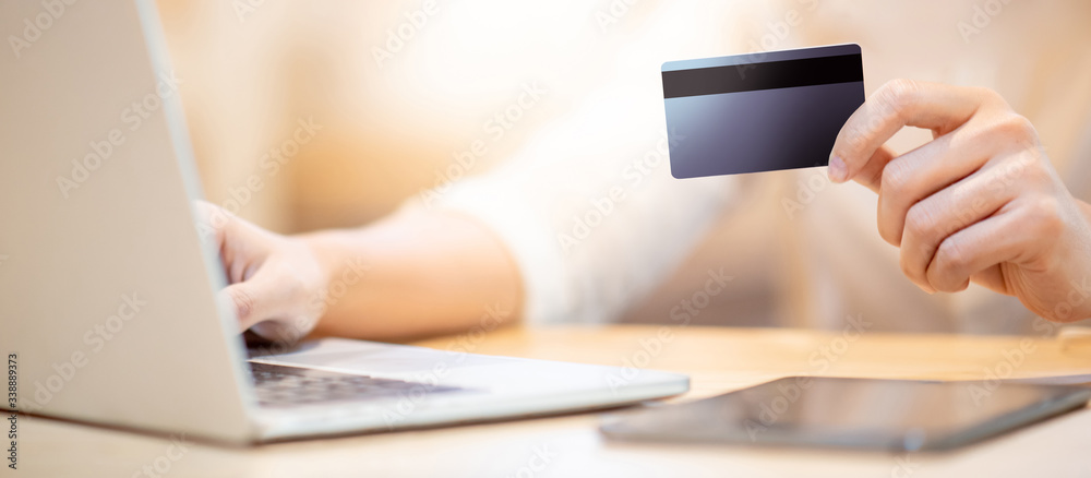 Fototapeta premium Male customer hand using credit card for online shopping during quarantine at home. Male shopper buying goods and making payment with electronic banking. Financial technology concept