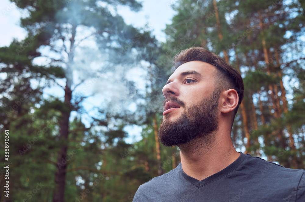 Portrait of a young, bearded man, on, against a background of wildlife. The concept of expedition, adventure and camping life. Portrait of a young, bearded man, on, against a background of wildlife. The concept of expedition, adventure and camping life.