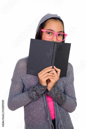 Studio shot of young beautiful teenage girl hiding behind book isolated against white background